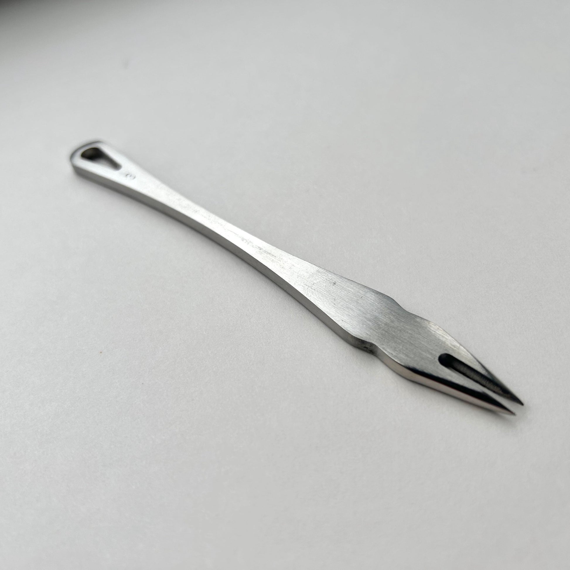 Metal distance gauge tool on a piece of leather