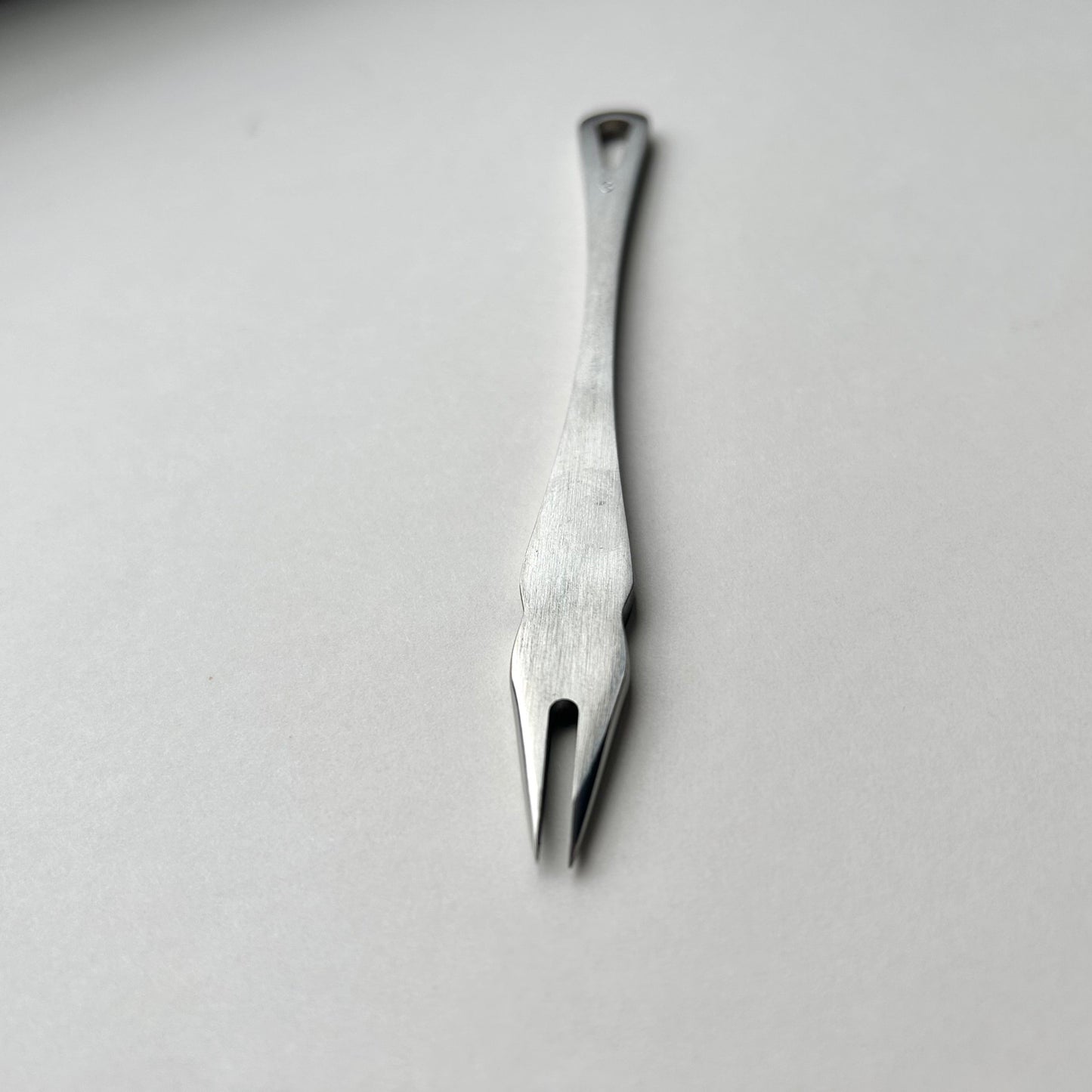 Metal distance gauge tool on a piece of leather