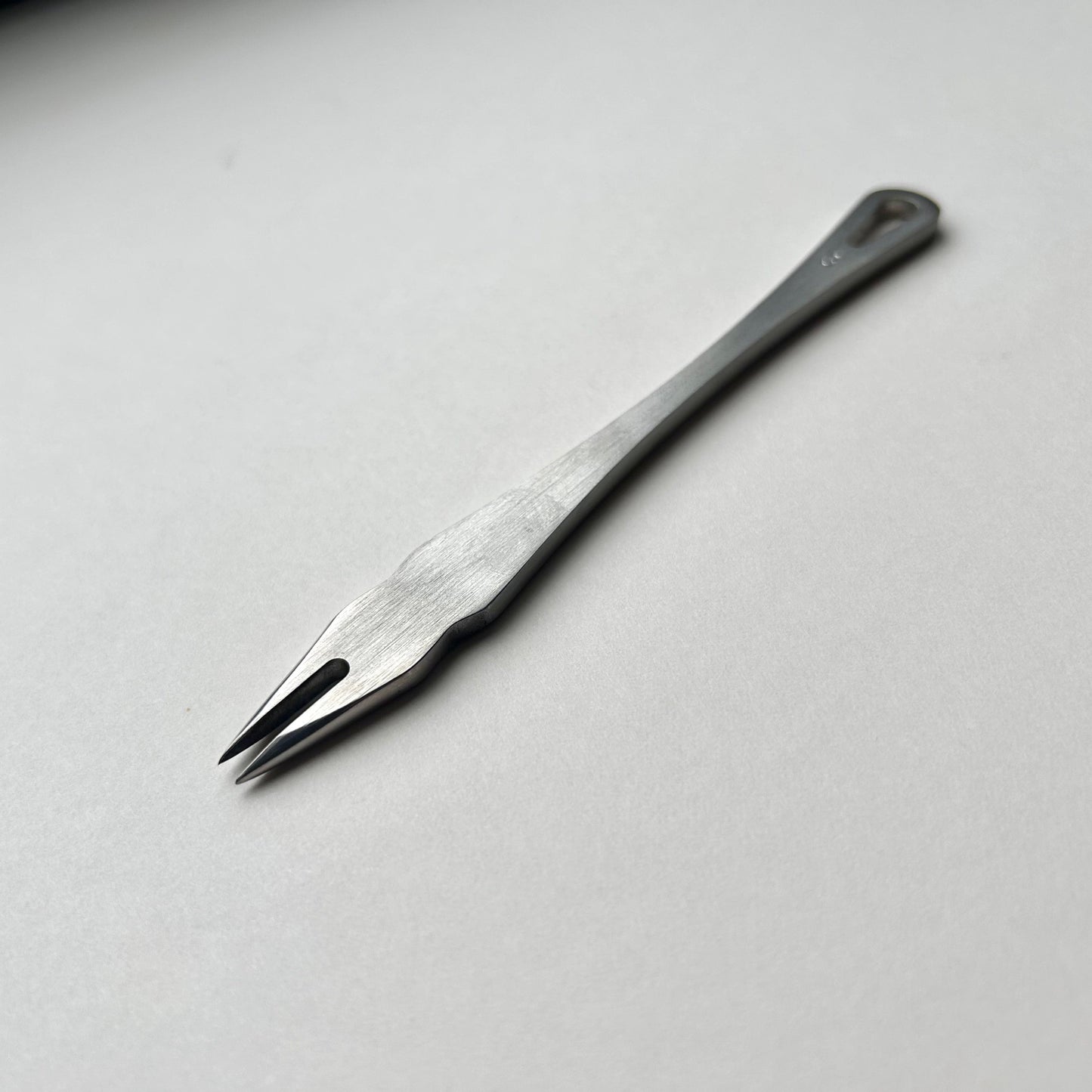 Metal distance gauge tool on a piece of leather