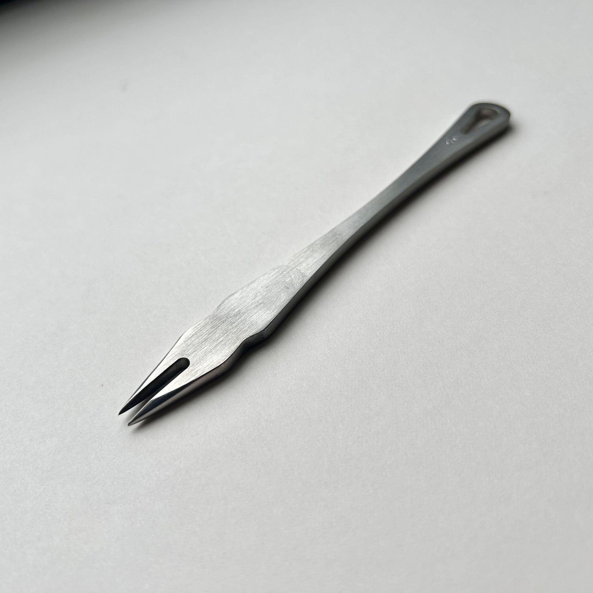 Metal distance gauge tool on a piece of leather