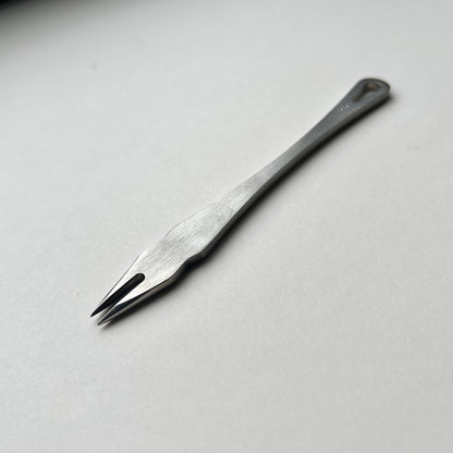 Metal distance gauge tool on a piece of leather