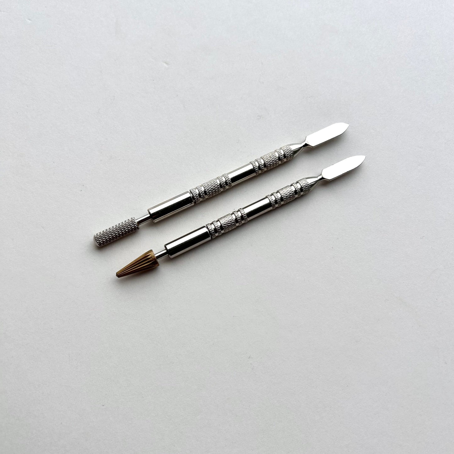 Two metallic leather edge dye pen tools with decorative patterns on a white background