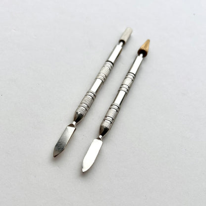 Two metallic leather edge dye pen tools with decorative patterns on a white background