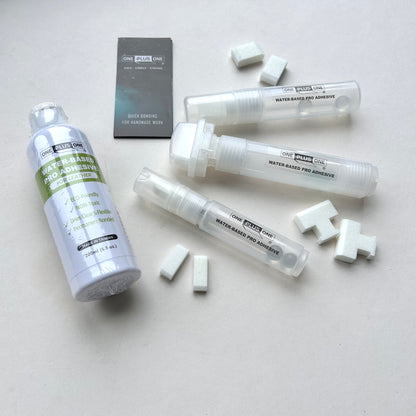 Set of adhesive products including bottles and tubes on a light gray background
