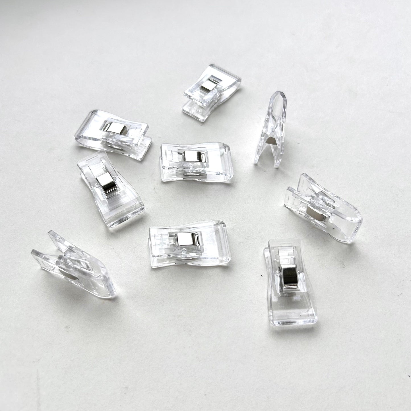 Clear plastic leather glueing clips on a light grey background