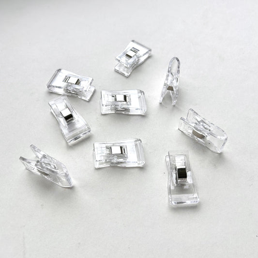 Clear plastic leather glueing clips on a light grey background