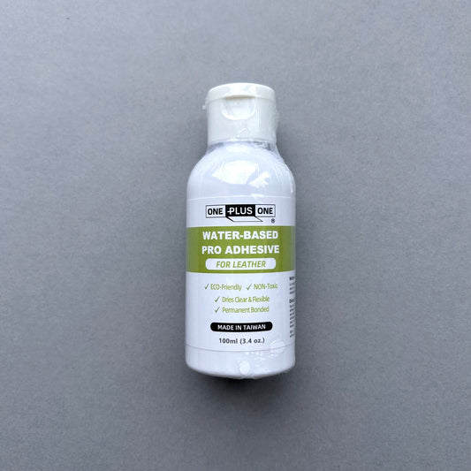 Bottle of water-based pro adhesive for leather on a gray background
