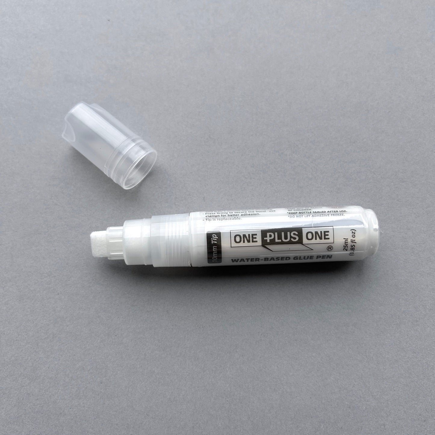 Water-based glue pen with cap on a gray background