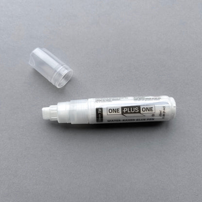 Water-based glue pen with cap on a gray background