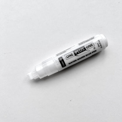 White glue pen labeled 'One Plus One' on a light gray background