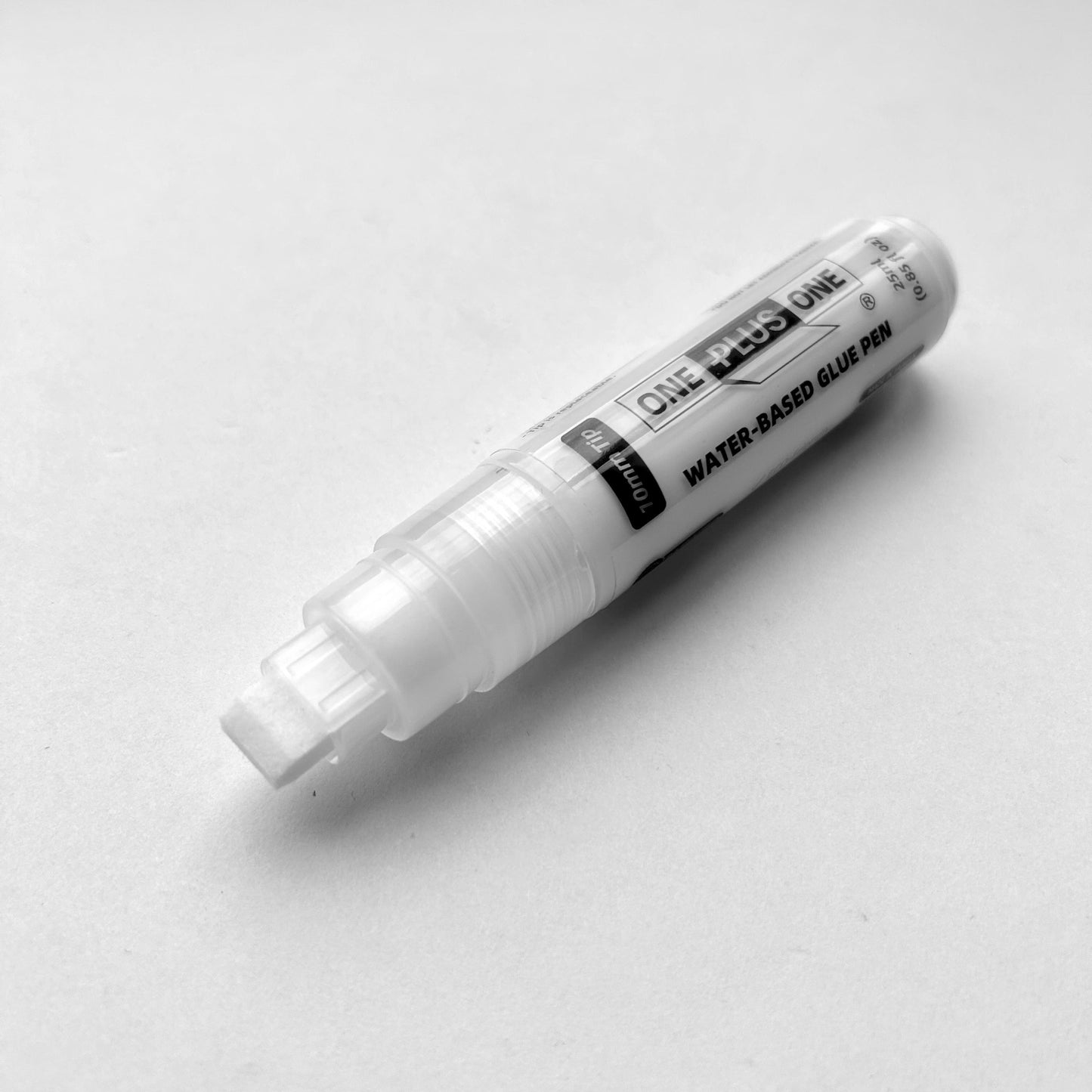 White water-based glue pen on a light gray background