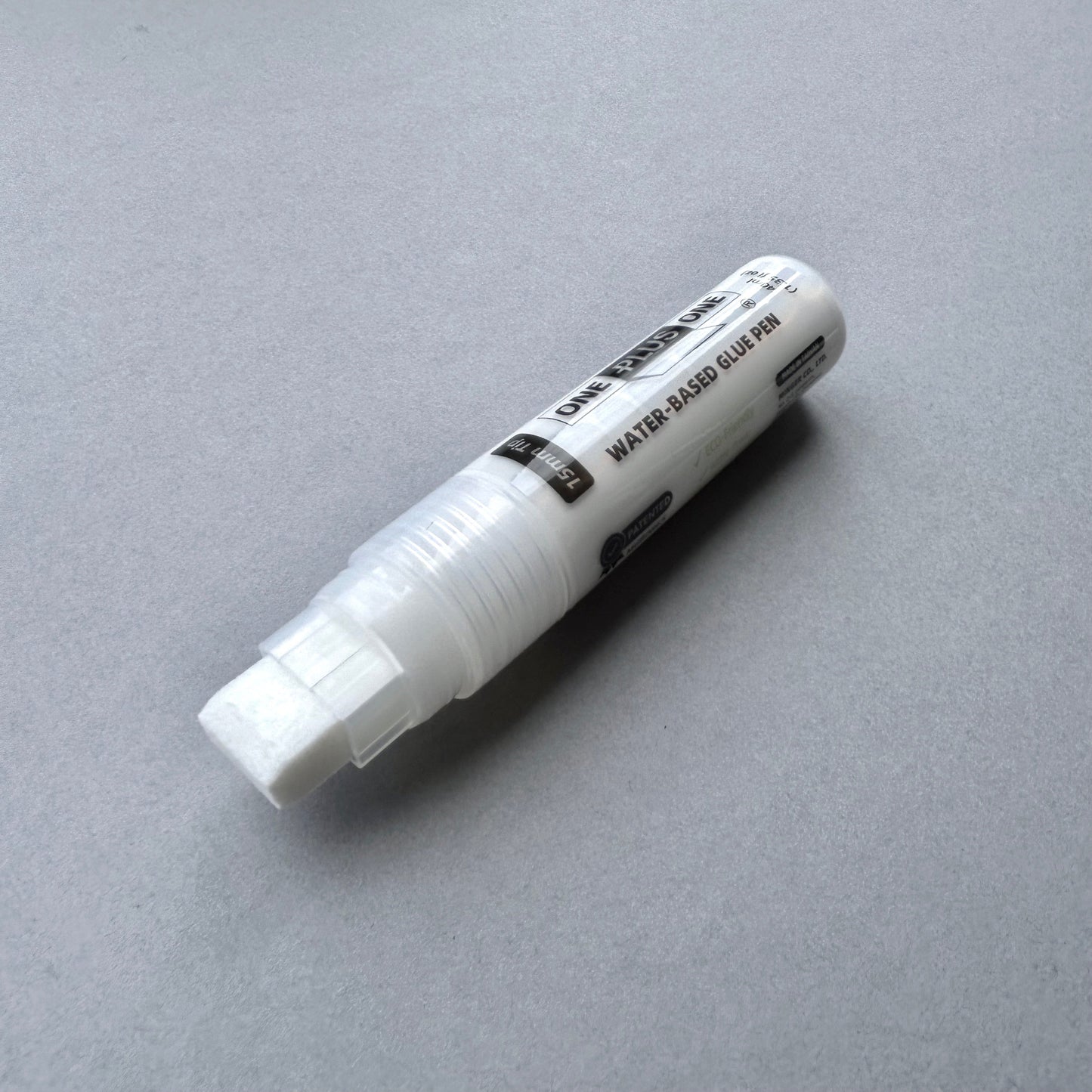 White water-based glue pen on a gray background