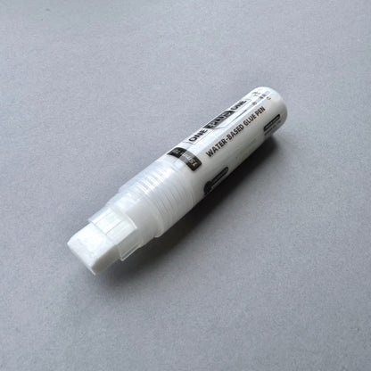 White water-based glue pen on a gray background