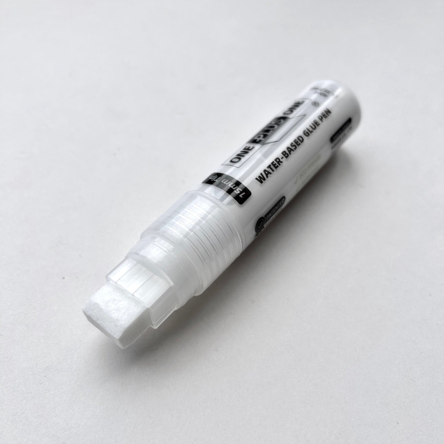 White water-based glue pen on a light gray background