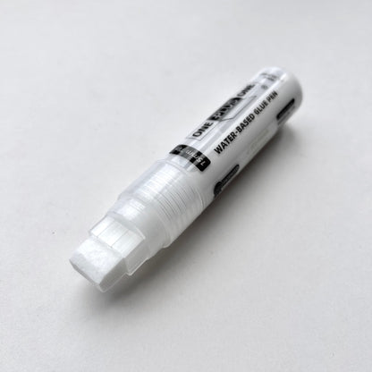 White water-based glue pen on a light gray background