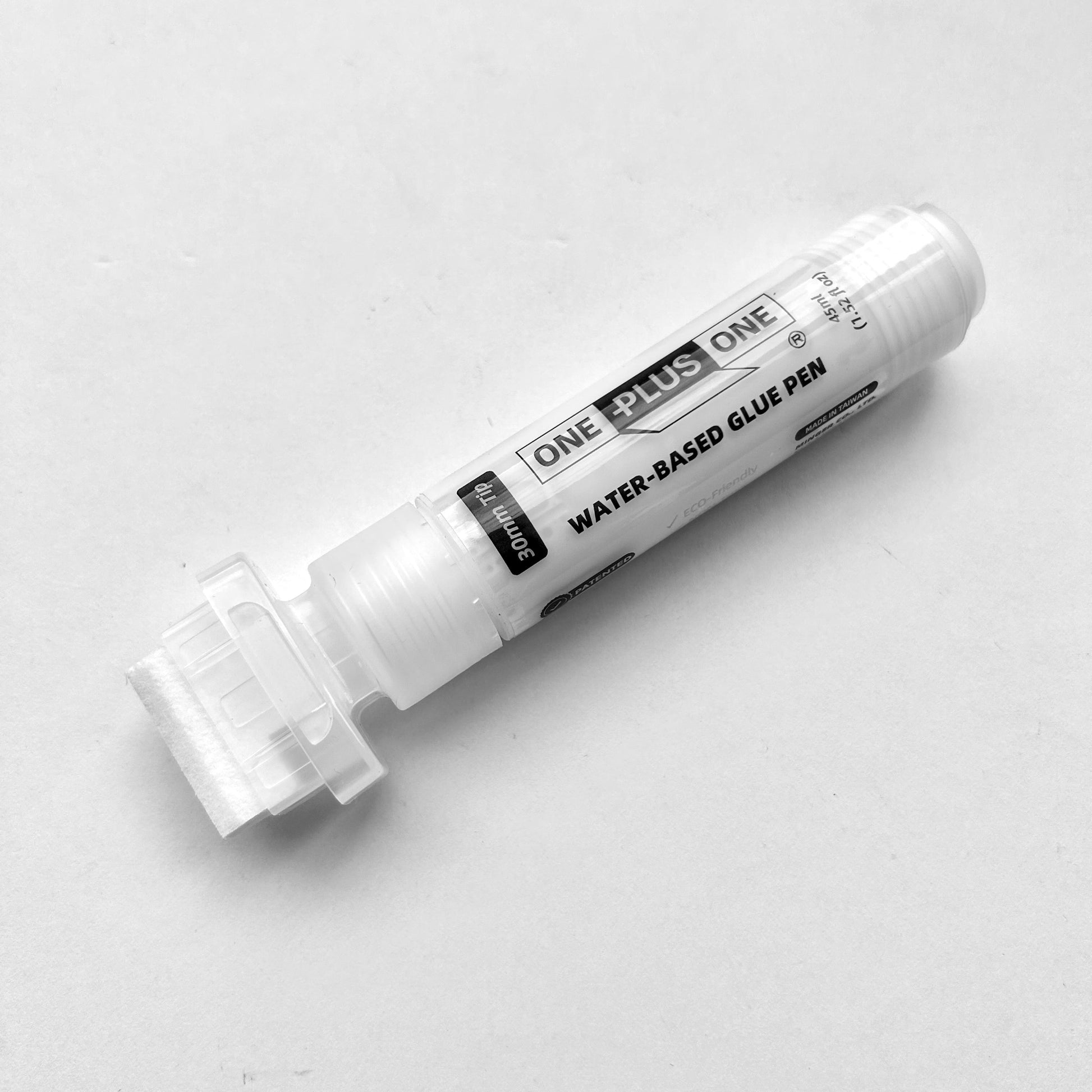 White water-based glue pen on a light gray background