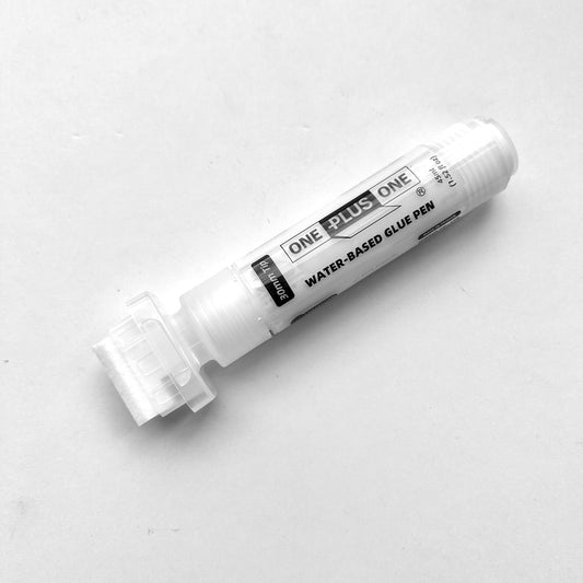 White water-based glue pen on a light gray background
