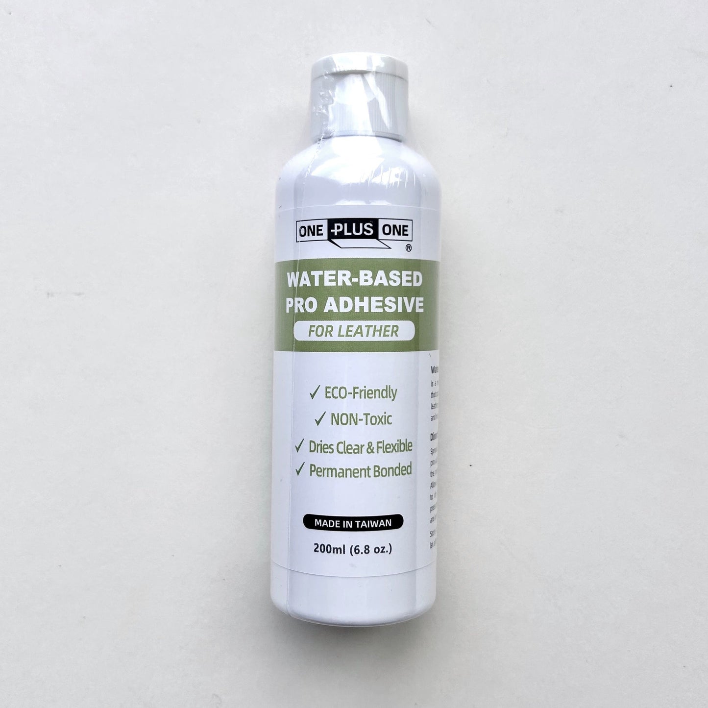 Bottle of water-based pro adhesive for leather on a white background