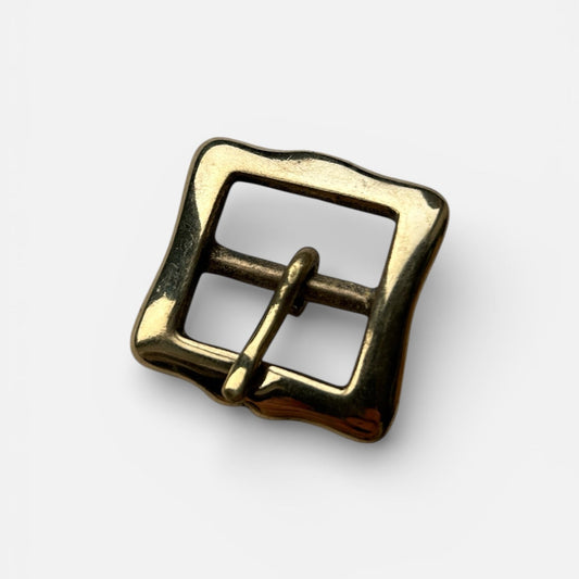 Gold metal buckle on a white background