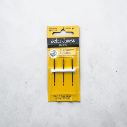 Packaged John James sewing machine needles on a grey background
