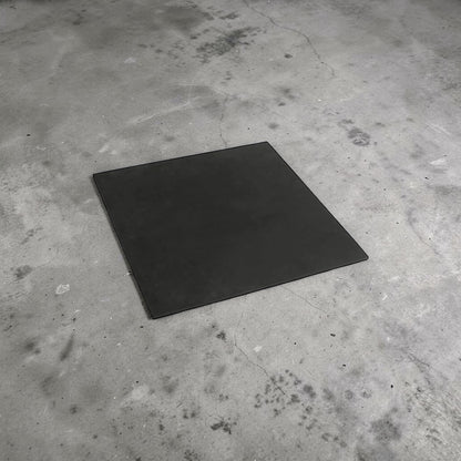 A black poundo board for leathercraft on a concrete floor