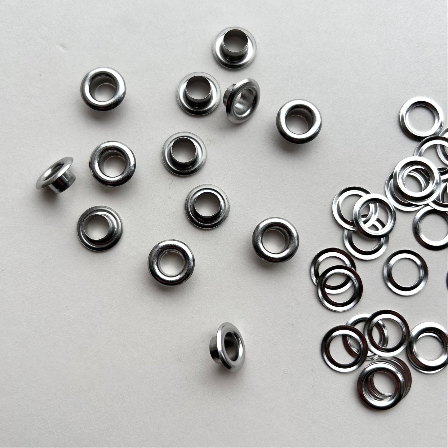 Metal eyelets scattered on a gray background