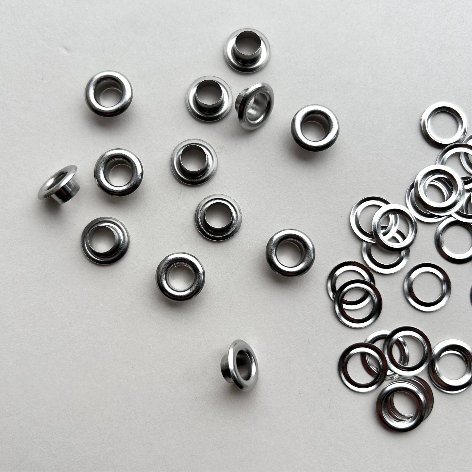Metal eyelets scattered on a gray background