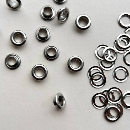 Metal eyelets scattered on a white background