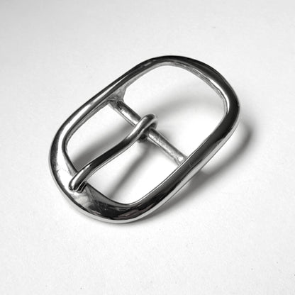A polished silver metal belt buckle with a rounded rectangular shape and a single prong, shown on a plain light gray background.