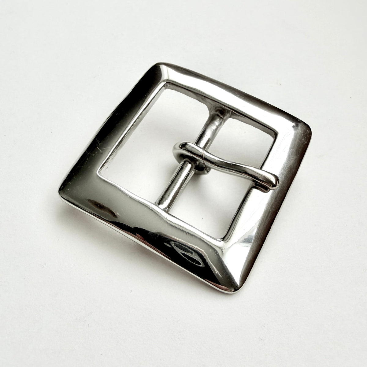 A polished silver-tone metal square buckle with a central bar and loop, photographed on a clean white background.