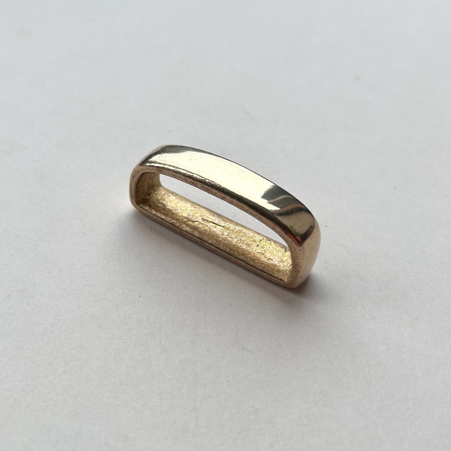 Solid brass belt loop keeper  on a white background
