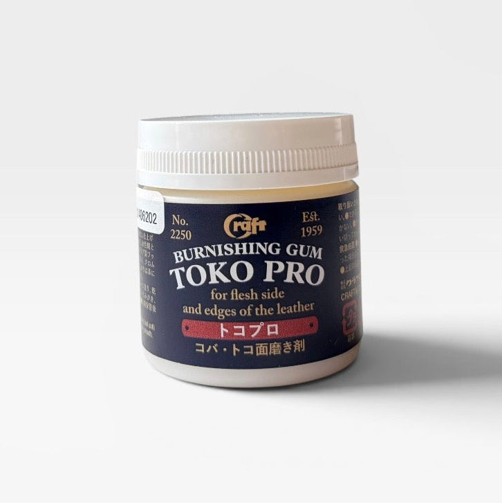 A jar of TOKO PRO Burnishing Gum for leather, featuring a white ribbed screw cap and a dark navy blue label with gold and white text.