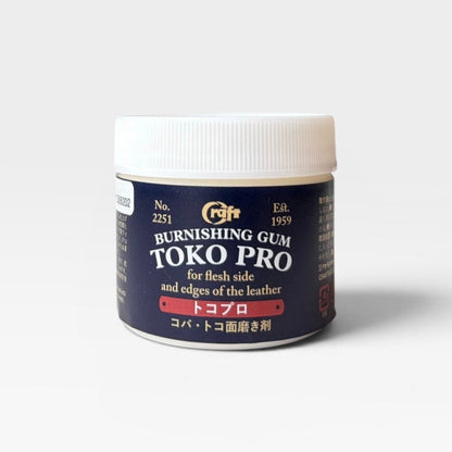 A jar of TOKO PRO Burnishing Gum in the Tokuba shade, featuring a dark navy blue label with gold and white text, and a white screw-on cap, set against a plain light gray background.