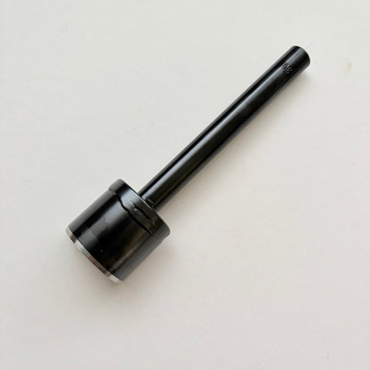 A black metal u shaped strap end punch with a silver steel cutting edge, shown on a plain light grey background.