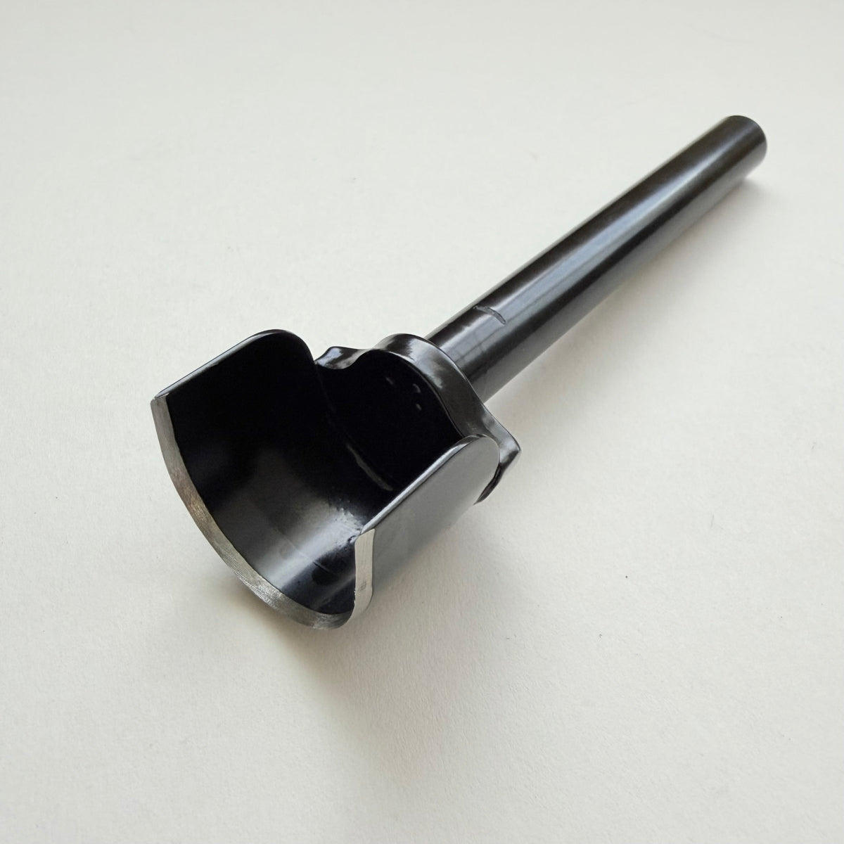 A black metal u shaped strap end punch with a silver steel cutting edge, shown on a plain light grey background.