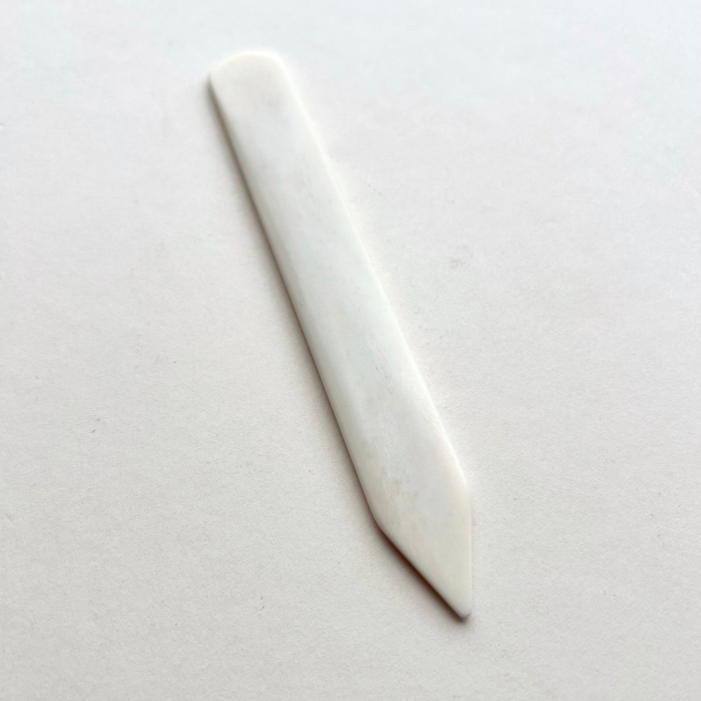 Leather bone creaser tool for folding leather on white background