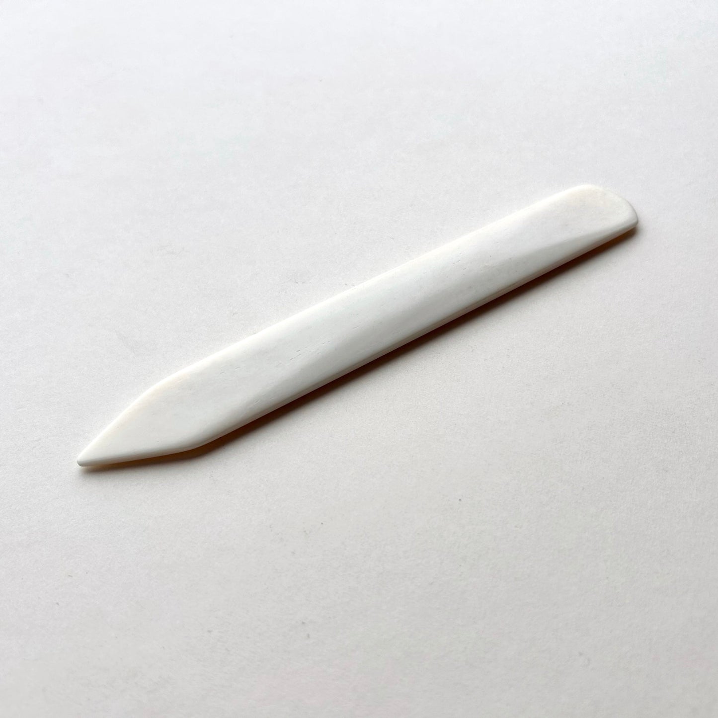 Leather bone creaser tool for folding leather on white background